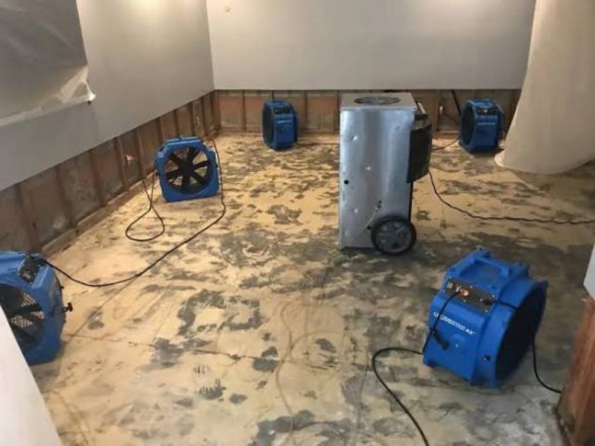 Air movers around a dehumidifier in a room with flood-cut walls – 77 Rapid Restore