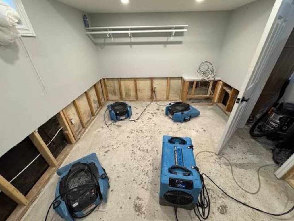 Air movers and a dehumidifier drying a room with flood-cut drywall – 77 Rapid Restore