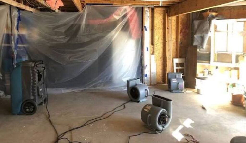 Plastic sheeting containment with a dehumidifier and air movers in a gutted room – 77 Rapid Restore